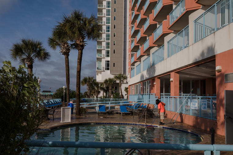 With expectations for a busy summer season, hotels in the U.S. and around the world are looking to hire back laid-off staff. Pictured here is an employee cleaning the pool at a hotel in Myrtle Beach, South Carolina, on April 11, 2021. (Bloomberg/Getty Images)